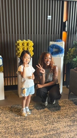 Sheriffah Arewa posing with a young visitor beside her work at Korea Craft Week