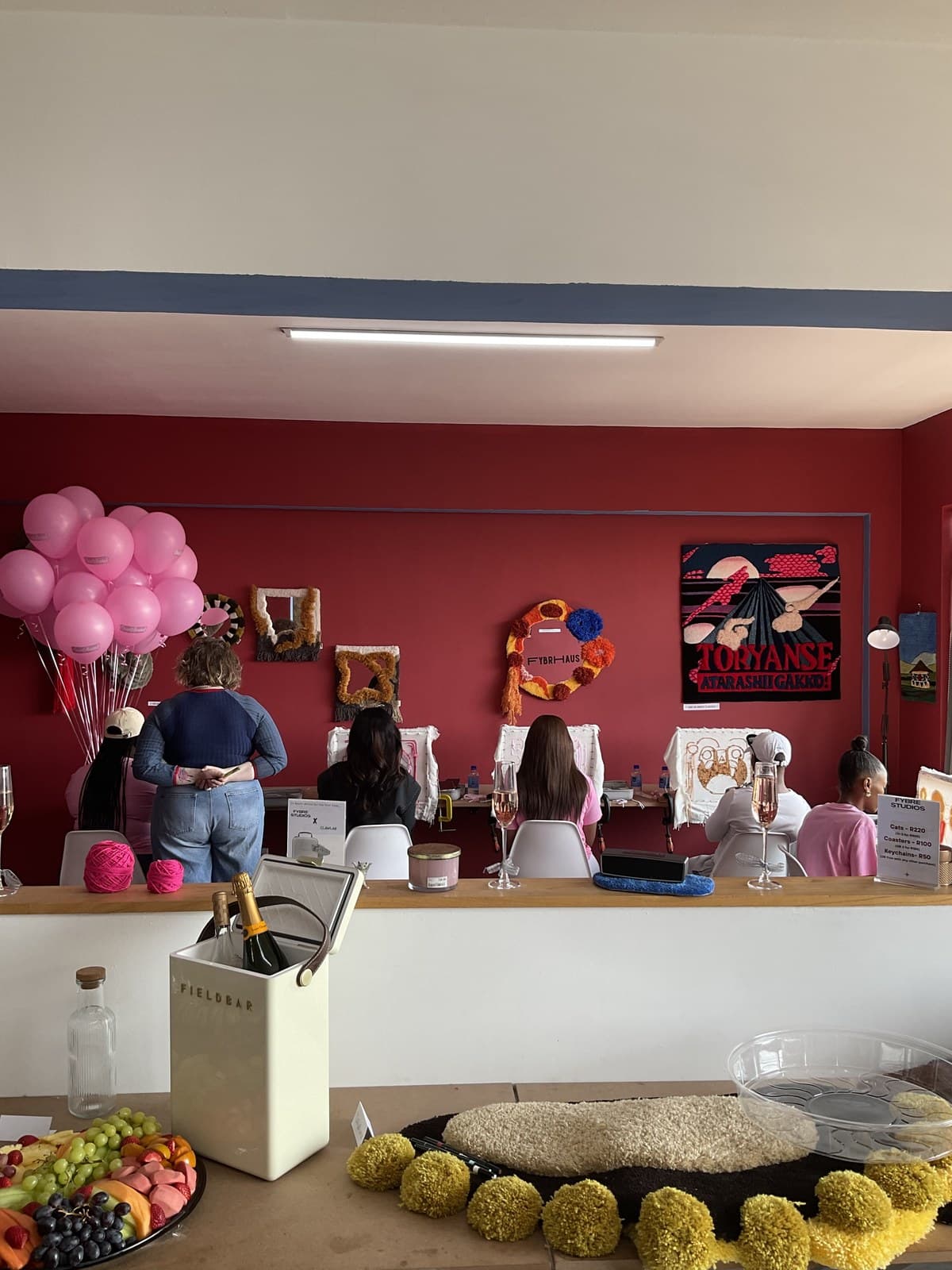 A private event set up at Fybre Studios with balloons, drinks, and tufting frames