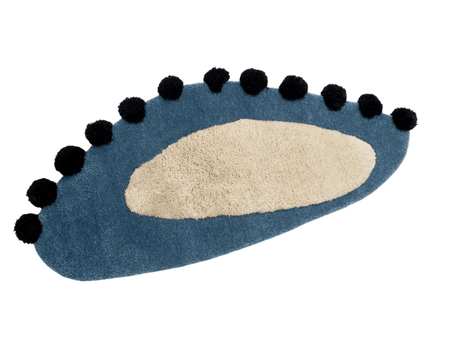 Oval scatter rug with a cream centre and black pom-pom trim