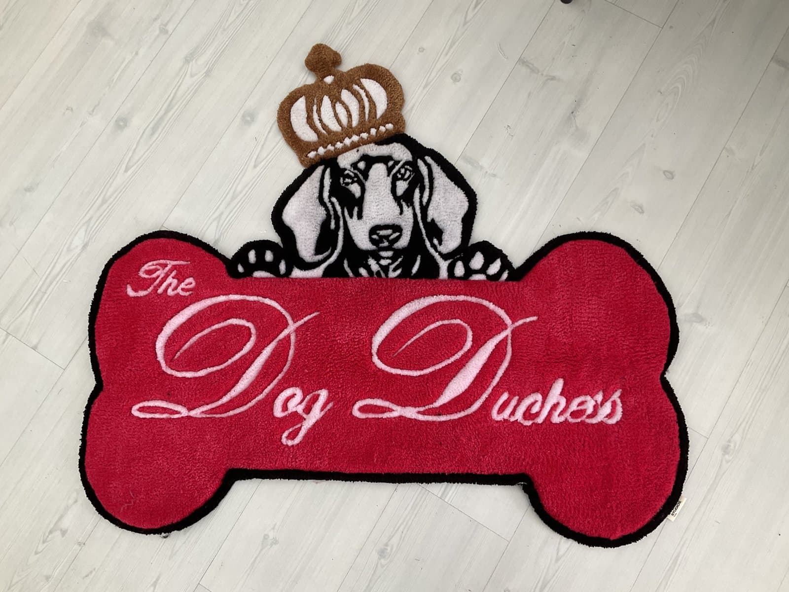 Hand-tufted bone-shaped rug reading ‘The Dog Duchess’