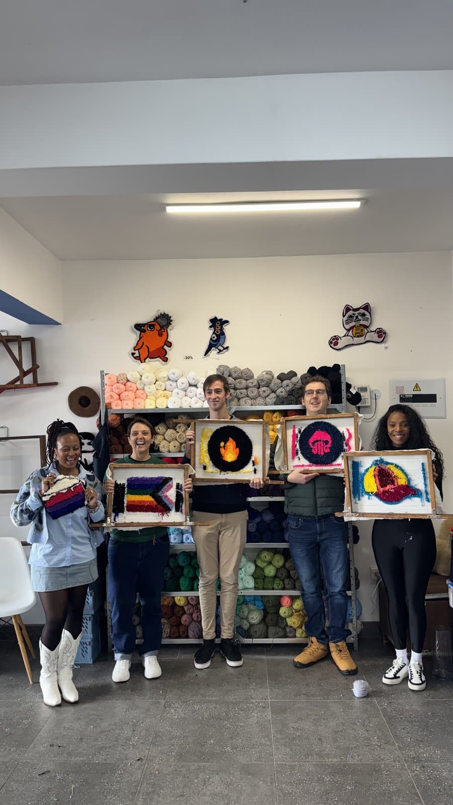 Group photo of students holding their finished tufted rugs