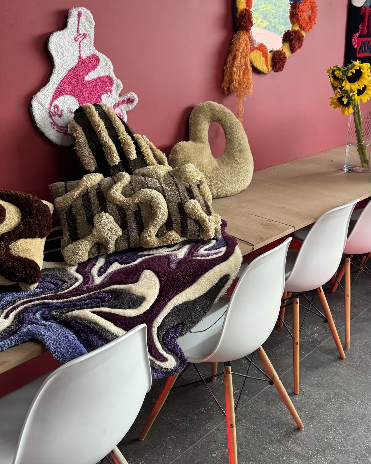 Colourful liquid-design tufted rugs laid out on a studio table