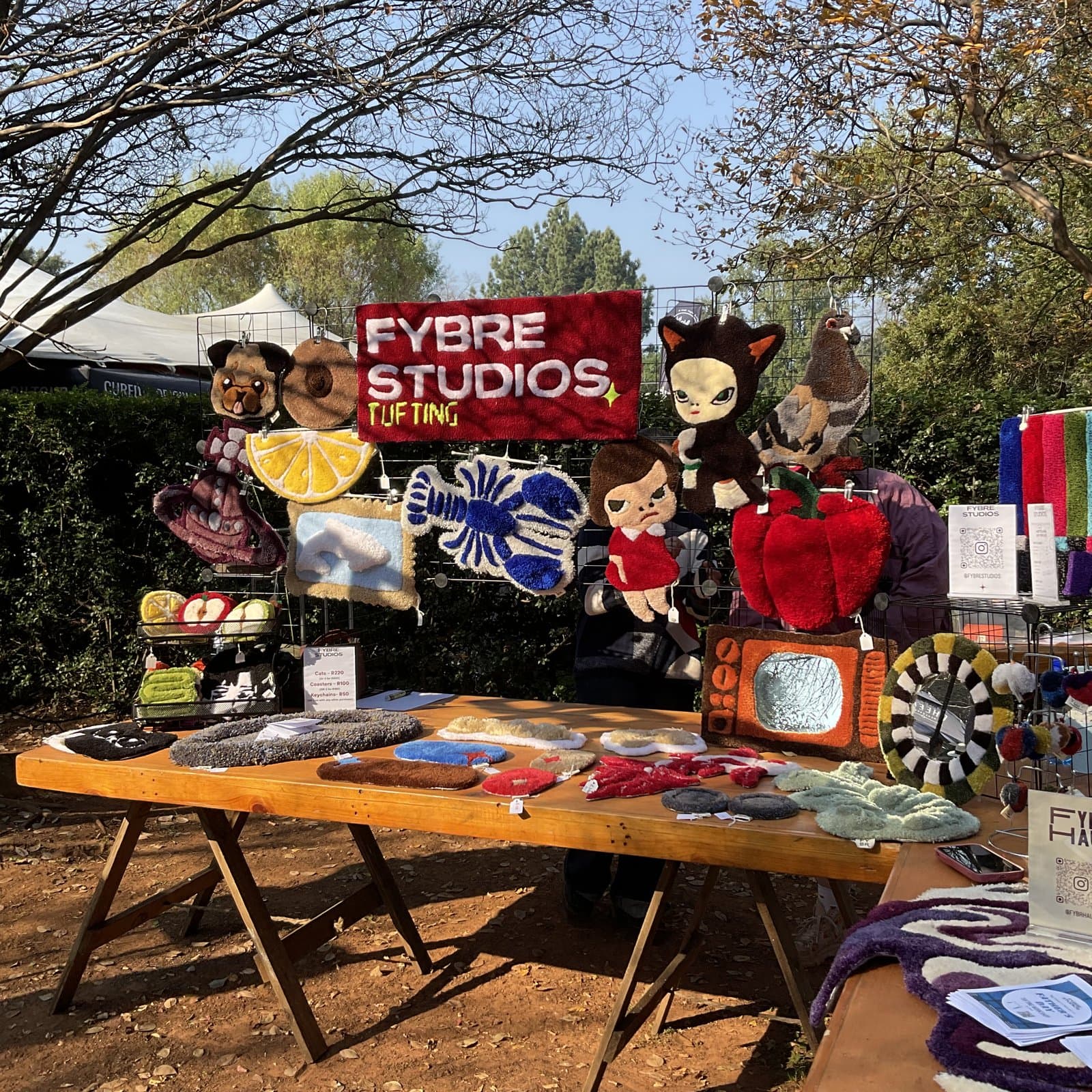 Tufted rugs and patches displayed on an outdoor market table
