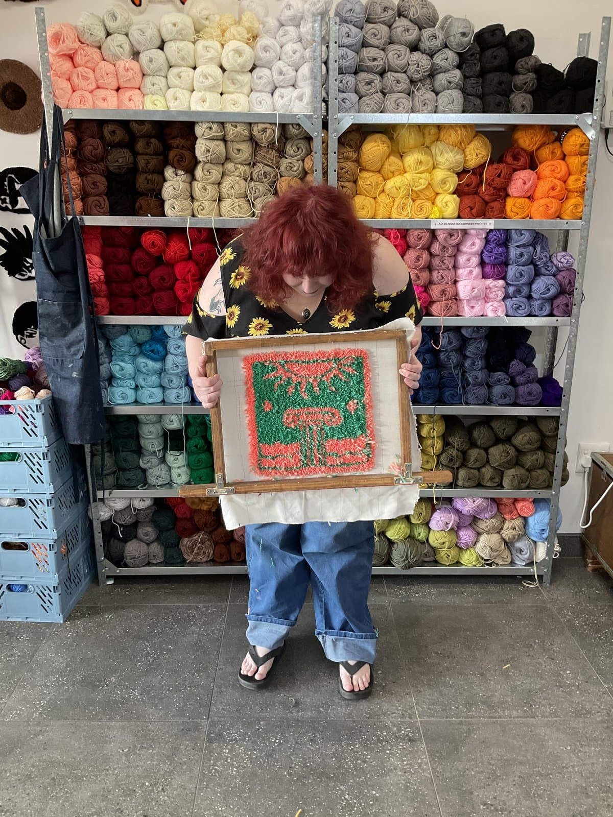 Student holding a colourful frog-design tufted rug