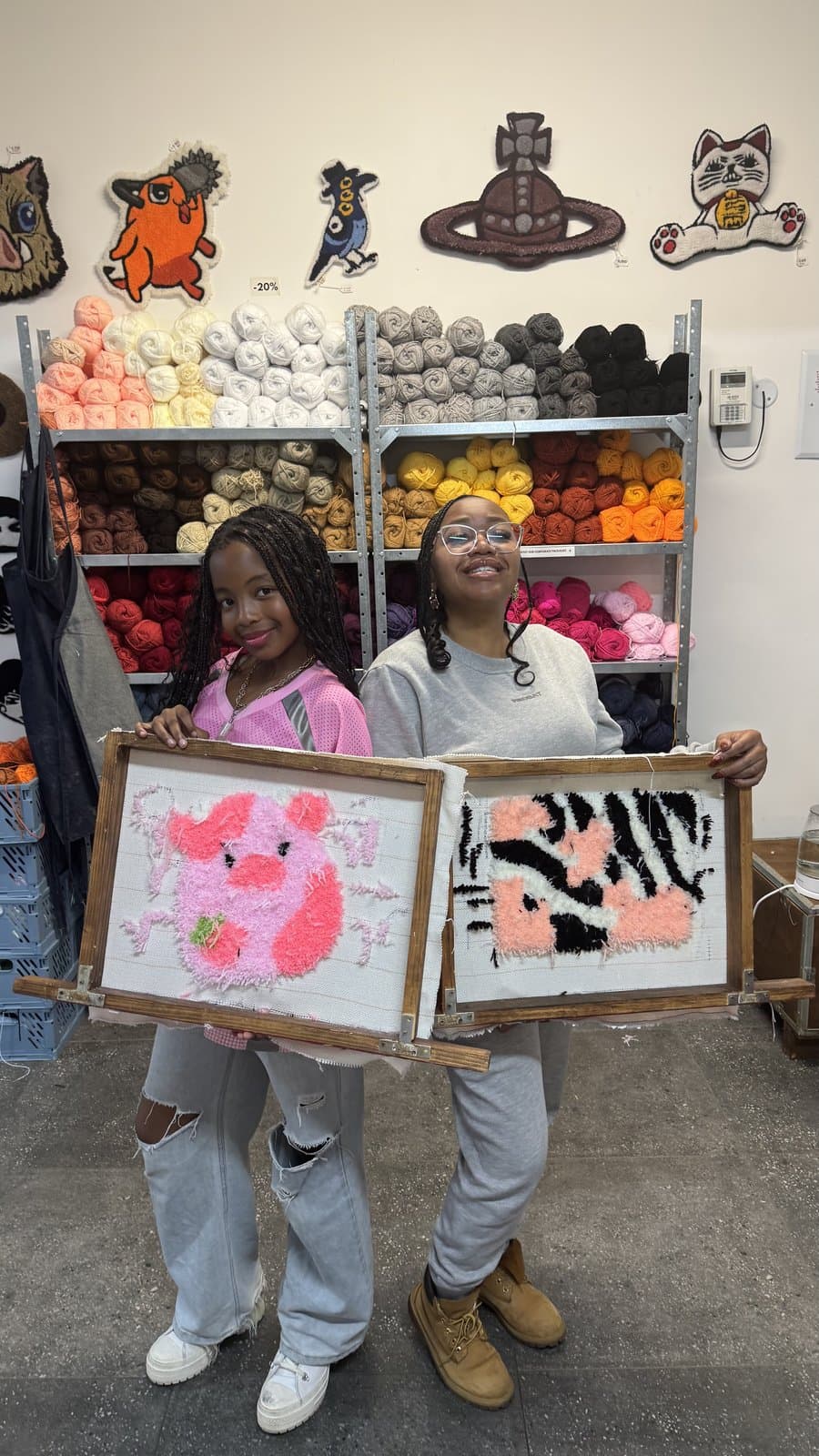 Student holding a pink and purple flower-design tufted rug