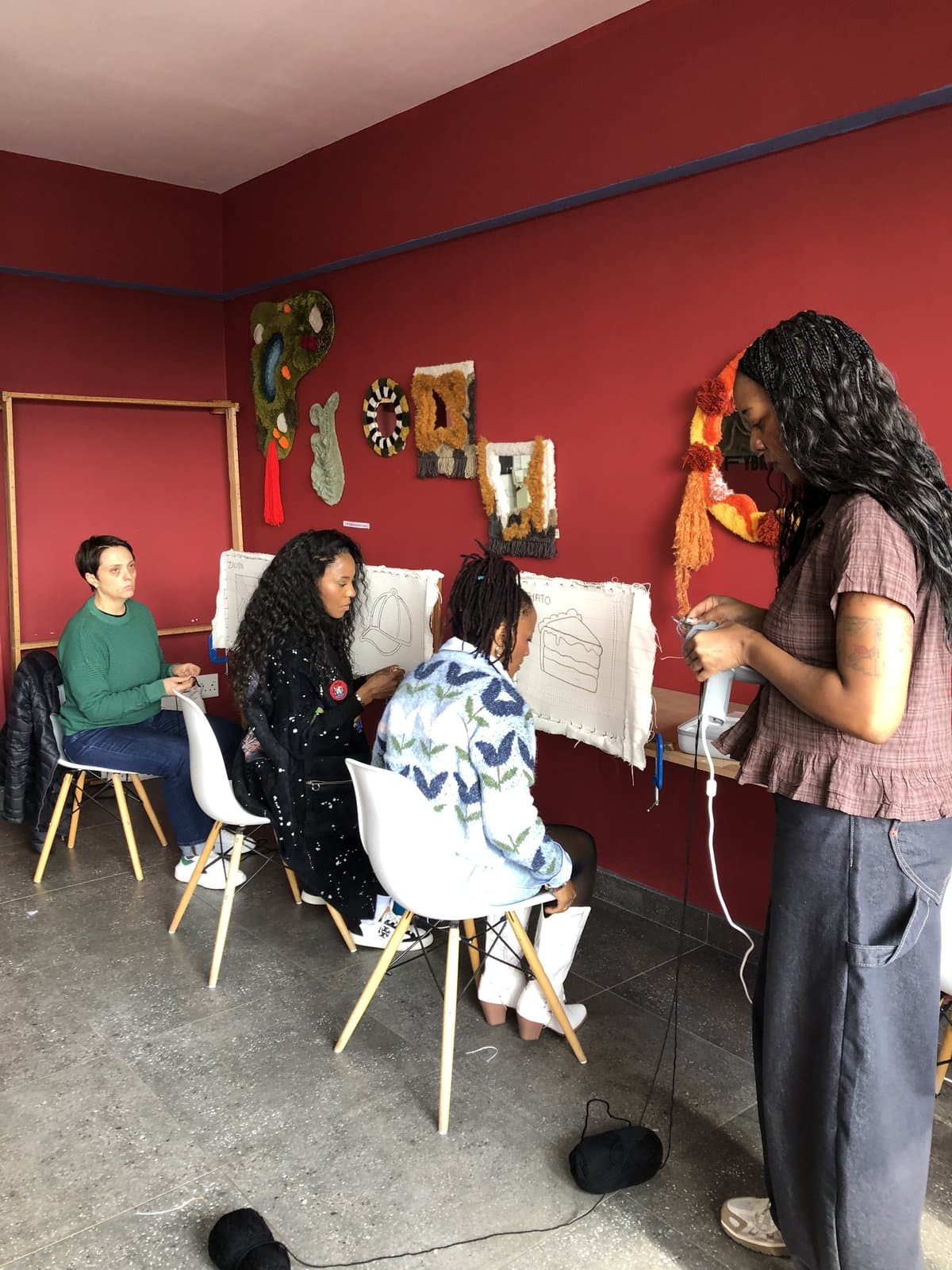 Students tufting rugs together in a studio class