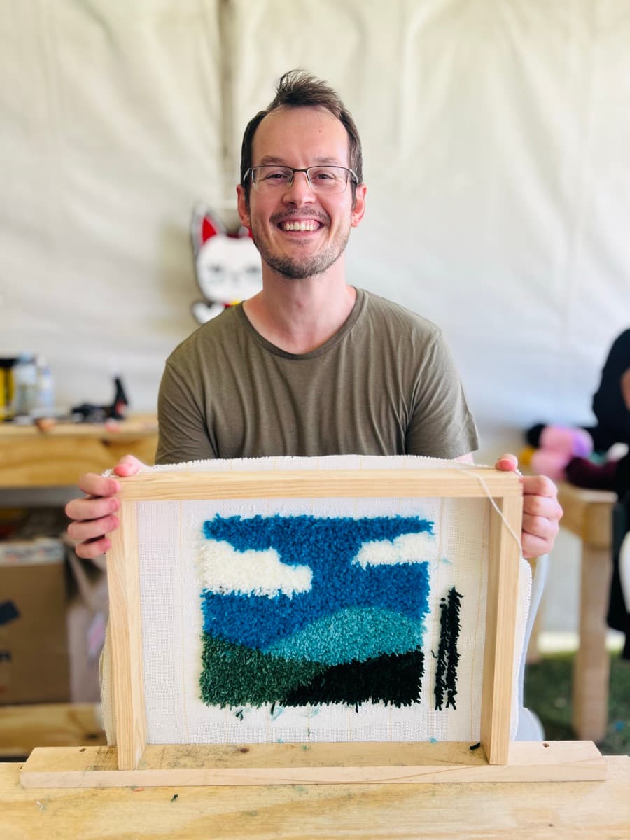Guest tufting a rug at a Fybre Studios class or market event